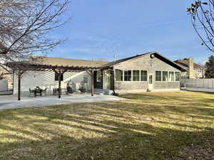 Back of house with a yard and a patio