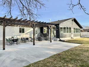 Back of property with a lawn, a patio area, and a pergola