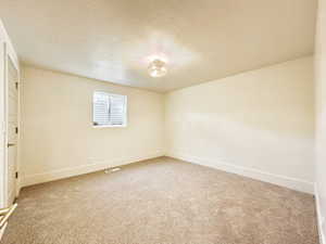 Spare room featuring carpet and a textured ceiling