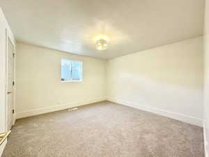 Carpeted empty room featuring a textured ceiling