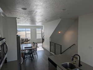 Kitchen featuring a textured ceiling, dark hardwood / wood-style flooring, sink, and stainless steel appliances