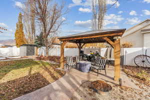 View of patio / terrace featuring a gazebo, a mountain view, a shed, and an outdoor fire pit