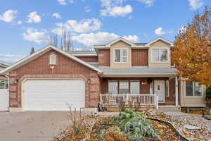 View of front property with covered porch and a garage