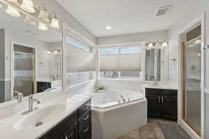 Bathroom with tile patterned floors, vanity, and separate shower and tub