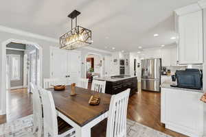 Dining area featuring light hardwood / wood-style floors, ornamental molding, and a chandelier