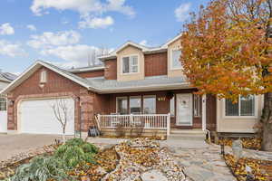 View of front of home with a porch and a garage