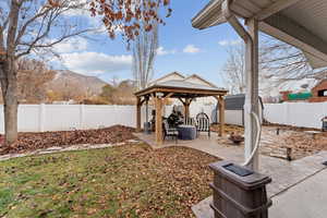 View of yard featuring a mountain view, a gazebo, a patio, and a storage unit