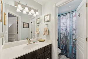 Bathroom with a shower with shower curtain, vanity, and toilet