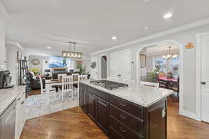 Kitchen featuring crown molding, dark hardwood / wood-style flooring, pendant lighting, and appliances with stainless steel finishes