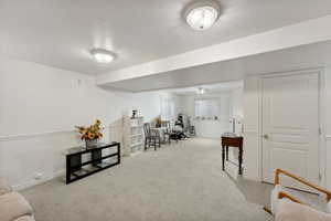 Sitting room featuring light colored carpet and a textured ceiling