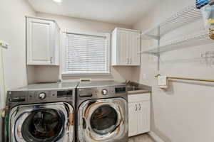 Laundry area with sink, cabinets, and independent washer and dryer