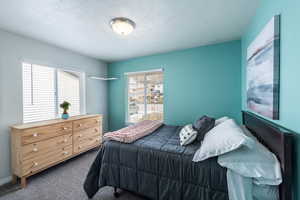 Carpeted bedroom with a textured ceiling