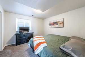 Carpeted bedroom featuring a textured ceiling