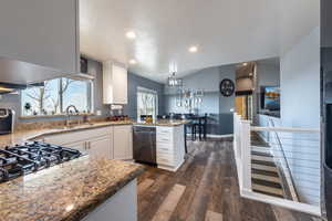 Kitchen featuring white cabinets, dark hardwood / wood-style floors, kitchen peninsula, and sink