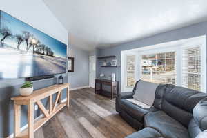 Living room featuring dark hardwood / wood-style floors and lofted ceiling