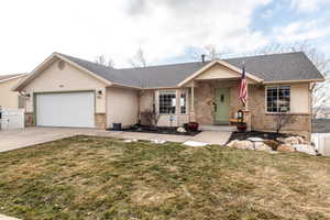 Ranch-style house featuring a front yard and a garage