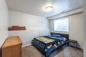 Bedroom with carpet and a textured ceiling