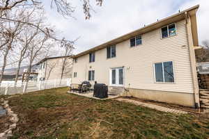 Rear view of property featuring a yard and a patio area