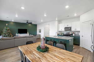 Dining room with light hardwood / wood-style floors, ceiling fan, and sink