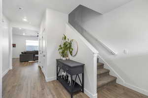 Stairs with hardwood / wood-style flooring and ceiling fan