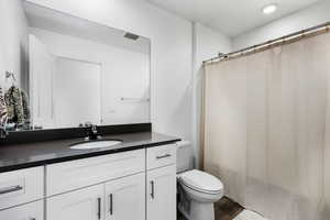 Bathroom with vanity, toilet, and wood-type flooring