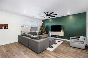 Living room with wood-type flooring and ceiling fan