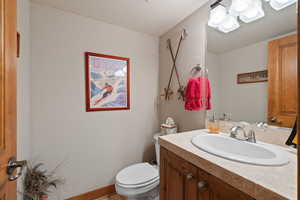 Bathroom with vanity, a textured ceiling, and toilet