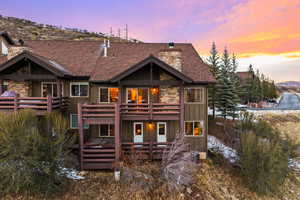 Back house at dusk featuring a wooden deck