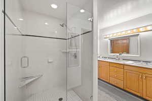 Bathroom featuring vanity and a shower with door