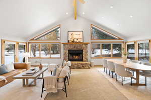 Carpeted living room featuring a fireplace, french doors, high vaulted ceiling, and beamed ceiling