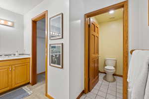 Bathroom featuring tile patterned floors, vanity, and toilet