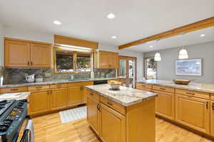 Kitchen featuring decorative backsplash, a center island, light hardwood / wood-style floors, and plenty of natural light