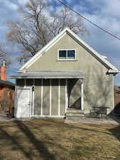 Rear view of property with a lawn and a patio