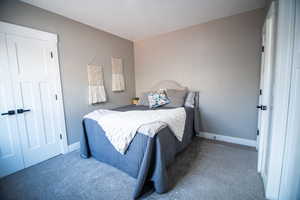 Carpeted bedroom with a closet and a textured ceiling