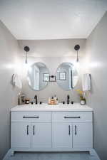 Bathroom with vanity and a textured ceiling