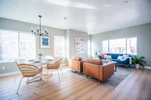 Living room featuring a notable chandelier, light hardwood / wood-style floors, and a textured ceiling