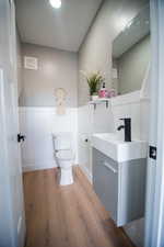 Bathroom with vanity, wood-type flooring, and toilet