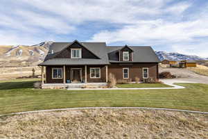 View of front of property featuring a mountain view, a porch, and a front yard