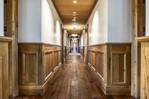 Corridor with wooden ceiling and dark wood-type flooring