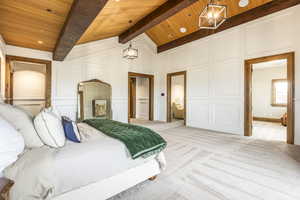 Bedroom with lofted ceiling with beams, light colored carpet, wooden ceiling, and an inviting chandelier