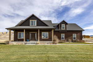 View of front of house with covered porch and a front lawn