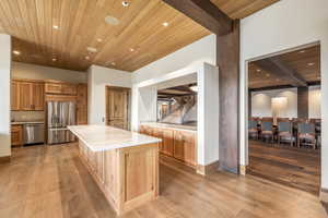 Kitchen featuring a center island, stainless steel appliances, light hardwood / wood-style flooring, and wooden ceiling