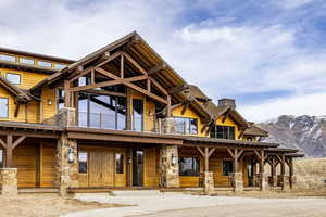 View of front of home with a mountain view and a balcony