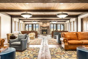 Living room featuring beam ceiling, wood-type flooring, and a fireplace