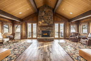 Unfurnished living room with hardwood / wood-style flooring, beam ceiling, wood ceiling, and french doors