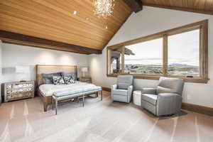 Bedroom with multiple windows, lofted ceiling with beams, wood ceiling, and a notable chandelier