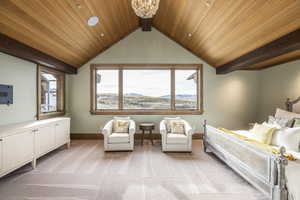 Carpeted bedroom featuring vaulted ceiling with beams, a mountain view, wooden ceiling, and an inviting chandelier