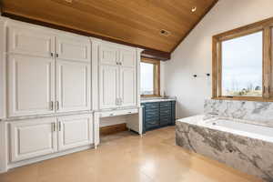 Bathroom featuring tiled tub, vanity, wood ceiling, and lofted ceiling