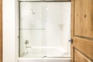 Bathroom with shower / bath combination with glass door