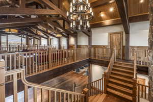 Interior space with wooden ceiling, high vaulted ceiling, an inviting chandelier, hardwood / wood-style flooring, and beamed ceiling